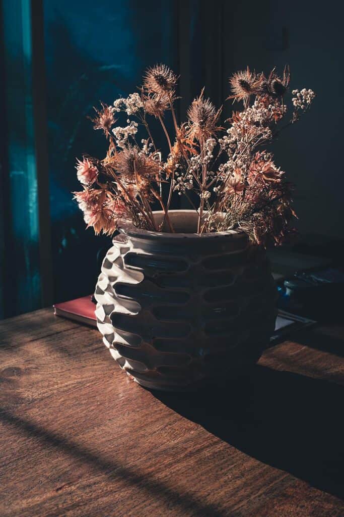 backlited flowers in vase on the table in sunset time